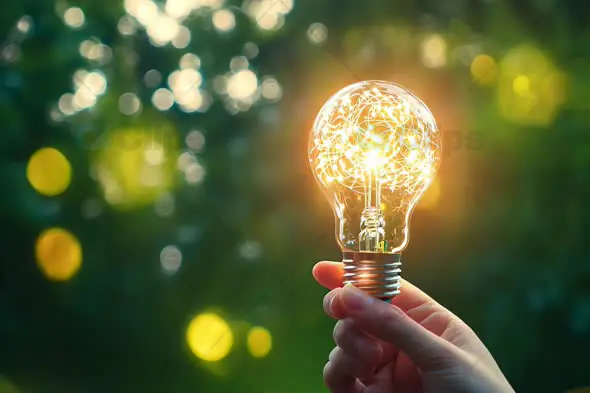 Hand Holding Glowing Lightbulb – Creative Energy and Innovation Concept