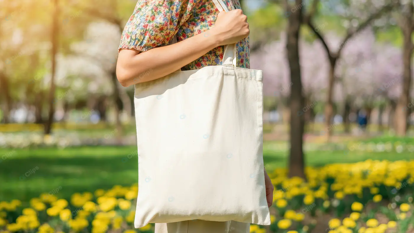 Stylish Woman Carrying Eco-Friendly Canvas Tote Bag in Park