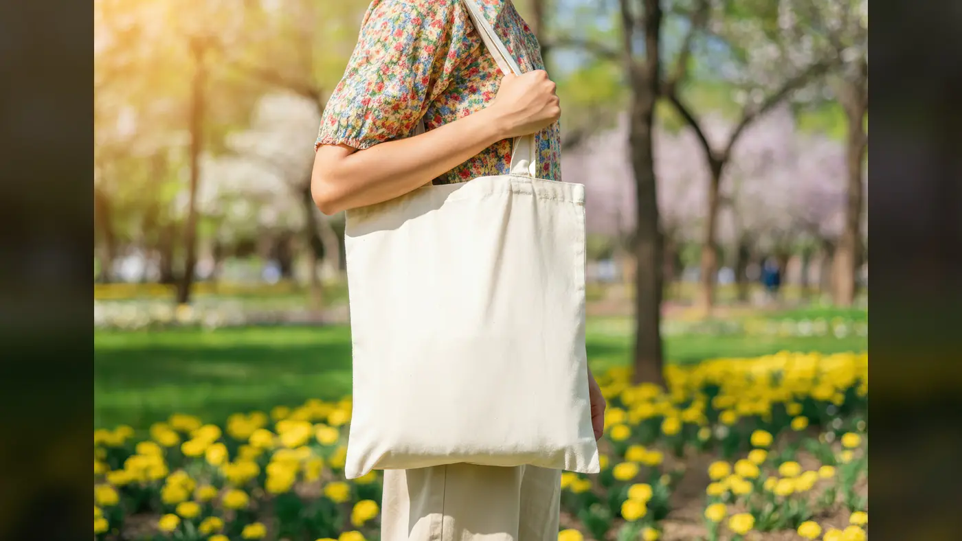 Stylish Woman Carrying Eco-Friendly Canvas Tote Bag in Park