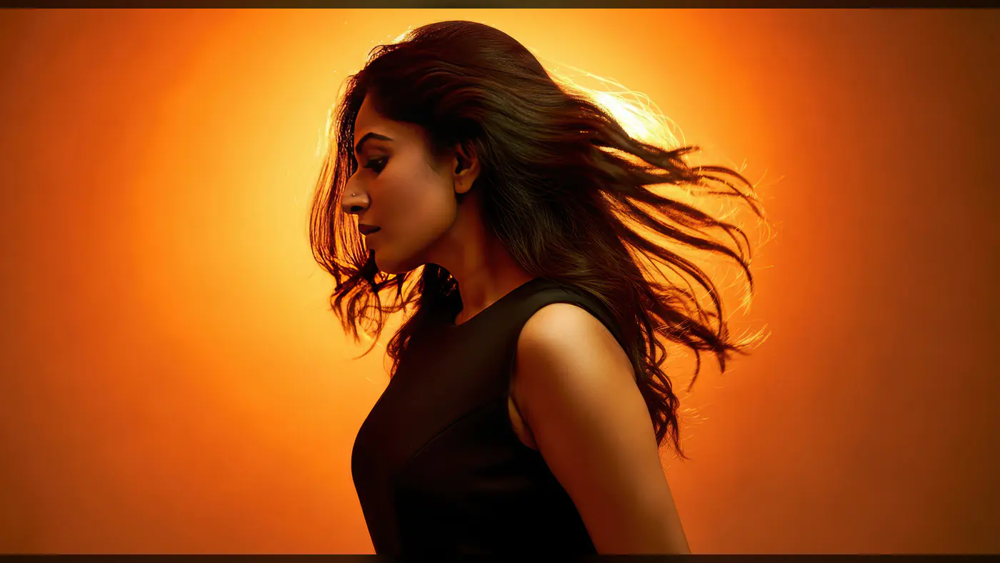 Stylish Indian Woman with Flowing Hair in Vibrant Orange Backlight