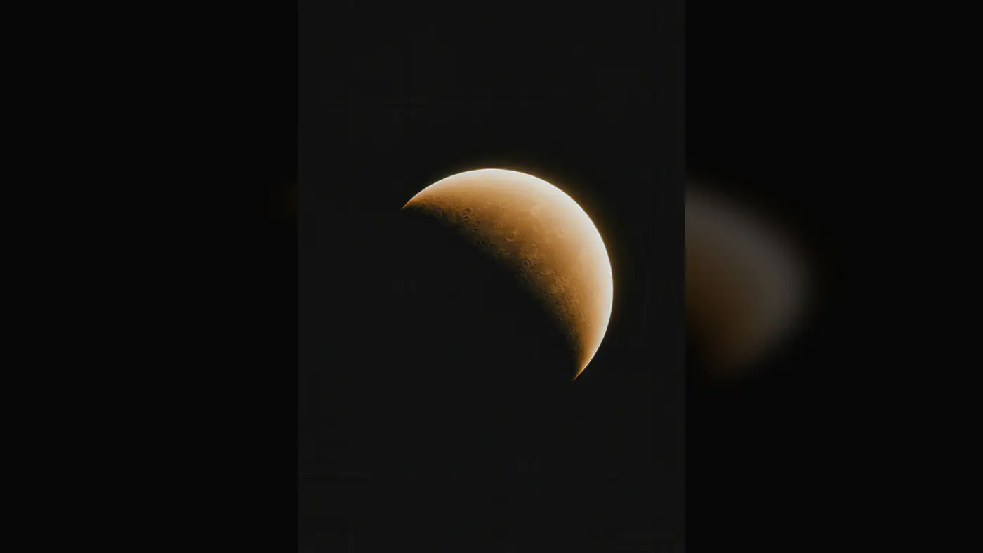 Crescent Moon with Detailed Surface Craters in Dark Sky
