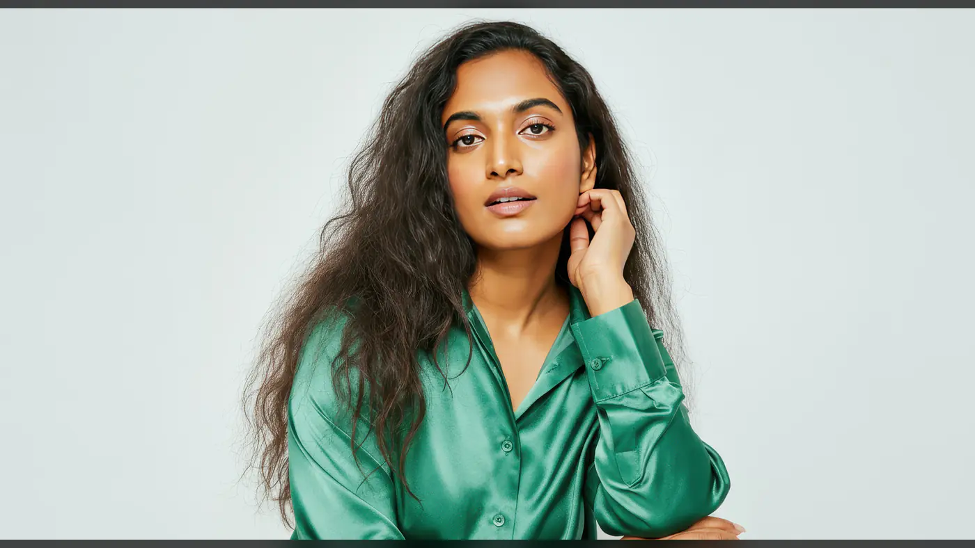 Elegant Woman in Green Satin Shirt on Minimalist Background