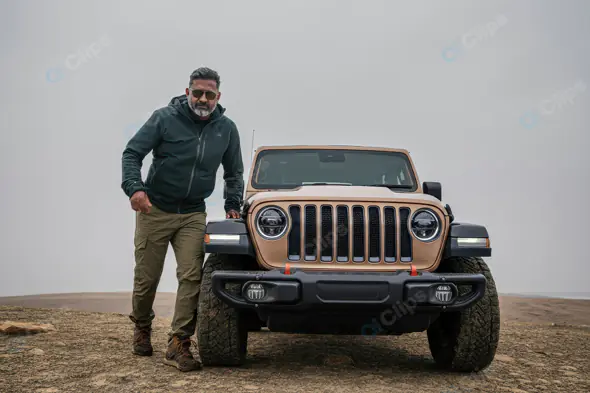 Adventurous Indian Man with SUV on Rugged Terrain