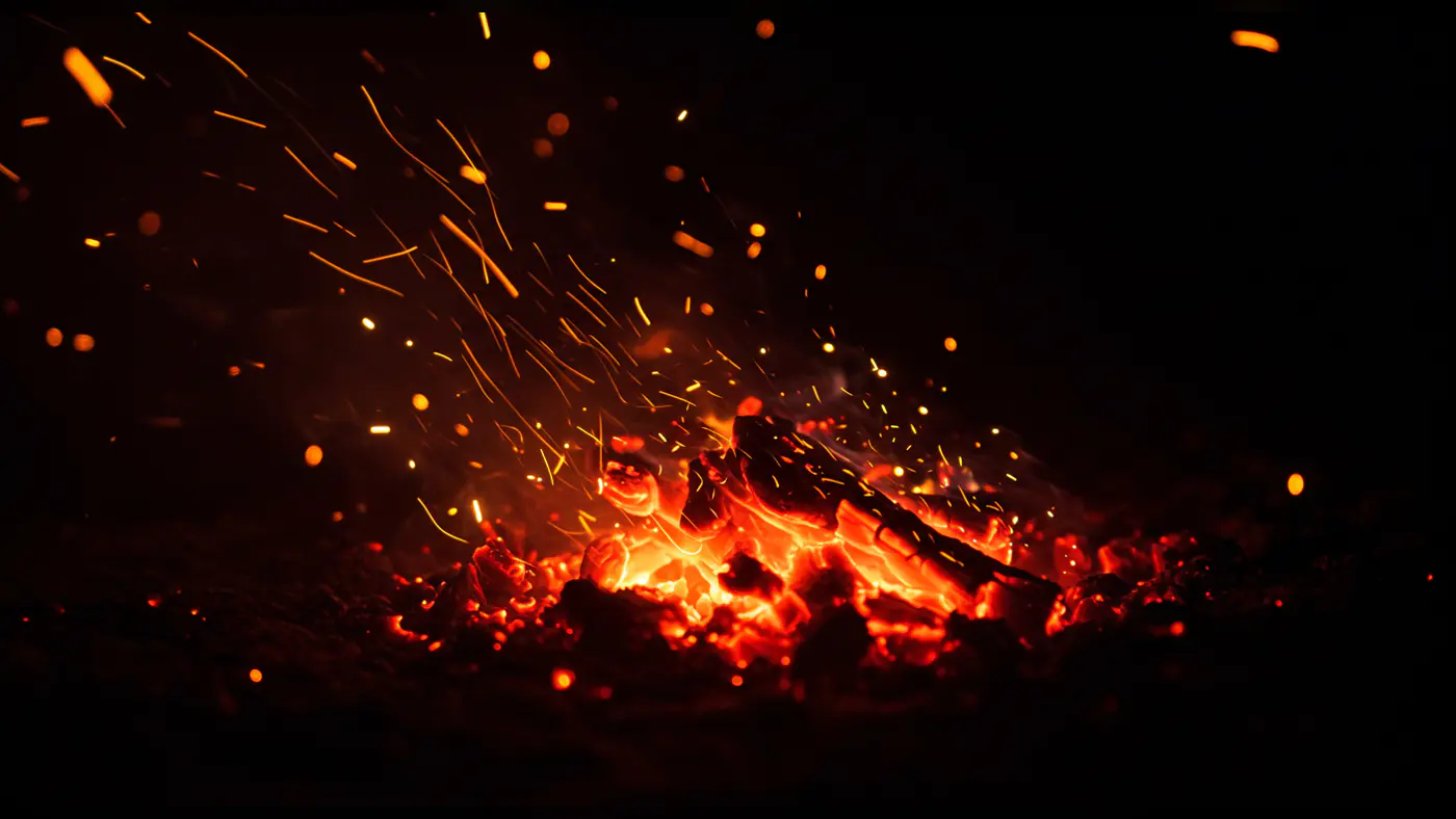 Glowing Charcoal Fire with Flying Orange Sparks Texture Background