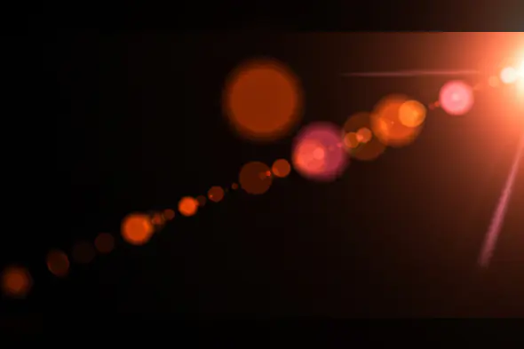 Diagonal Red-Orange Lens Flare Trail with Bokeh Circles
