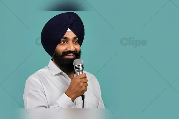 Sikh Man Speaking into Microphone on Solid Background