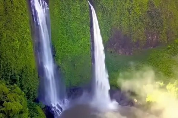 Majestic Twin Waterfalls Cascading Through Lush Green Cliffs