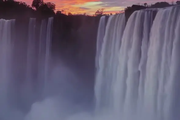 Majestic Waterfall Cascade at Sunset with Vibrant Sky