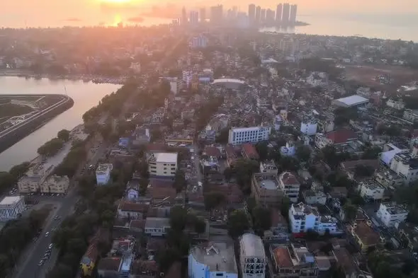 Aerial Sunset View of Urban Coastal City with Modern Skyline