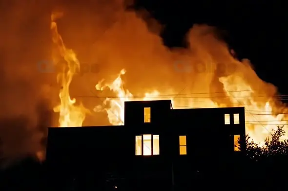 House Silhouette Against Raging Fire at Night