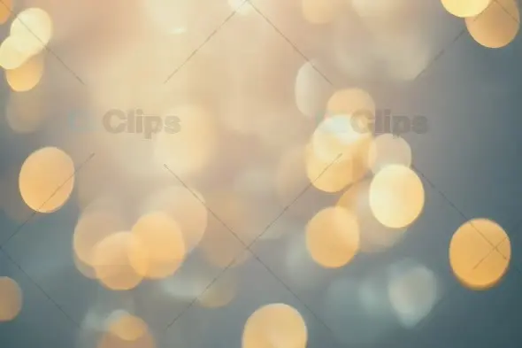 Ethereal Golden Bokeh Lights on Soft Blue Background