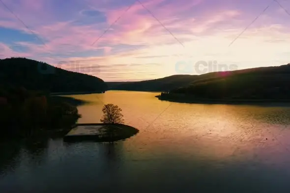 Serene Lake Sunset with Golden Reflections and Mountain Silhouettes