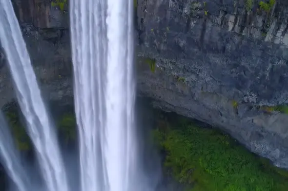 Majestic Waterfall Cascade Against Rocky Cliff Face