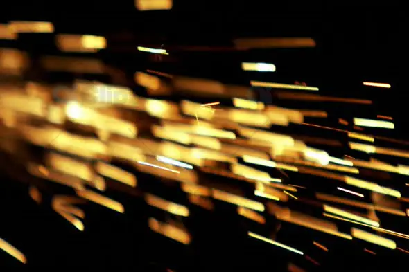 Golden Sparks Flying Horizontally in Dark Background