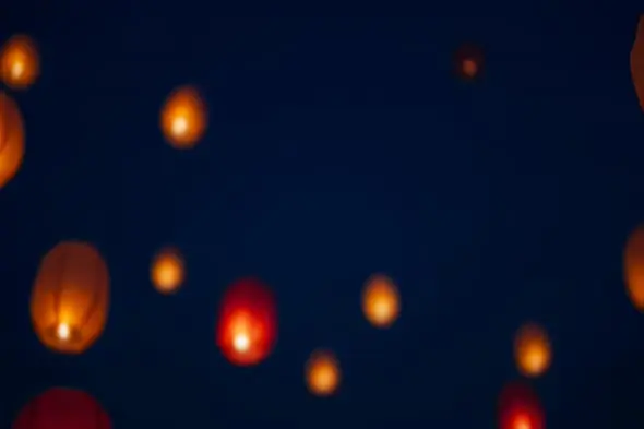 Glowing sky lanterns floating in dark night