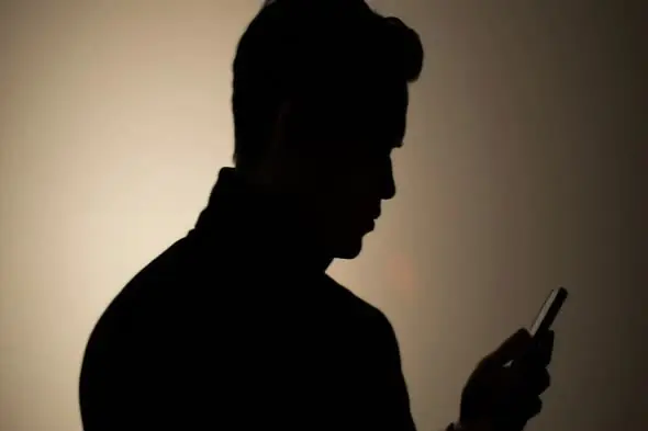 Shadowy Figure Using Mobile Device