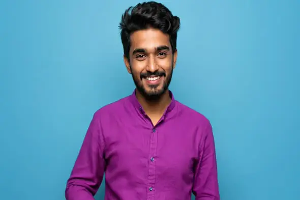 Confident Indian Man in Purple Kurta Smiling on Blue Background