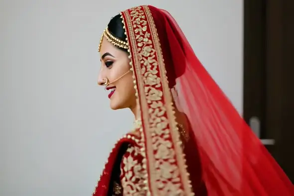 Smiling Indian bride in red wedding dupatta