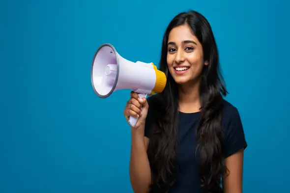 Indian Woman Announcer Holding Megaphone on Blue Background