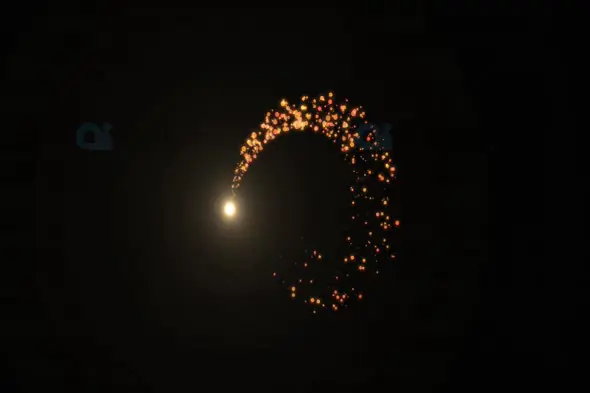 Golden Arc of Sparkling Particles on Dark Background
