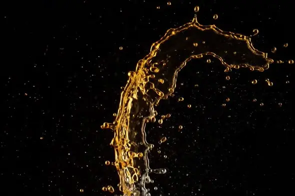 Golden Liquid Splash Arc Against Black Background