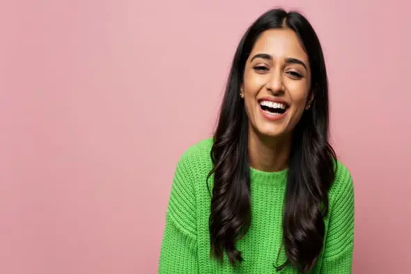 Joyful Expression in Bright Green Sweater Against Pink Background