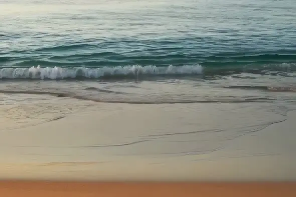 Tranquil Ocean Waves Gently Rolling onto Sandy Beach