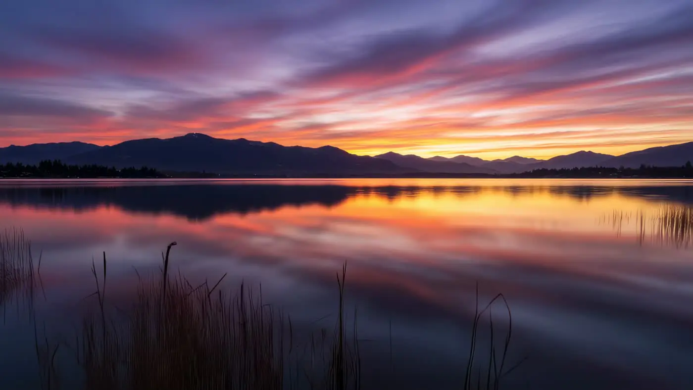 Serene Mountain Lake Reflects Vibrant Sunset Sky Colors | AIClips