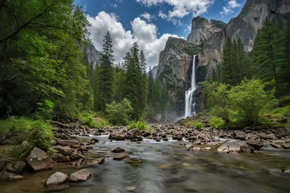 Majestic Waterfall Cascades Through Towering Mountain Landscape