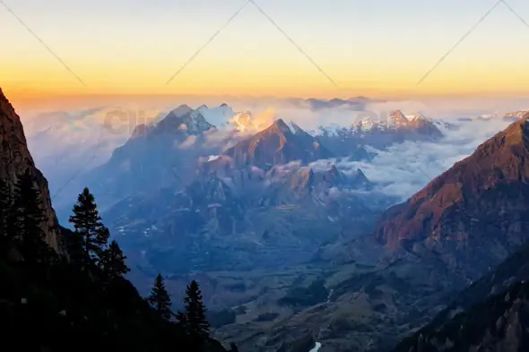 Breathtaking Mountain Range at Sunrise with Mist and Golden Light