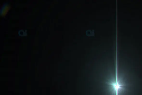 Bright Vertical Light Beam with Starburst Flare on Dark Background