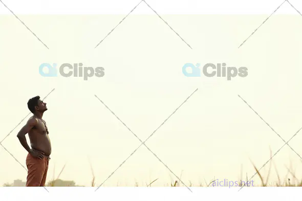 Pensive Indian Farmer Standing in the Field at Sunrise