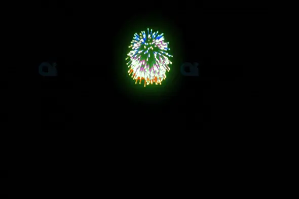 Multicolor Fireworks Burst in Green, Blue, and Yellow Against Night Sky