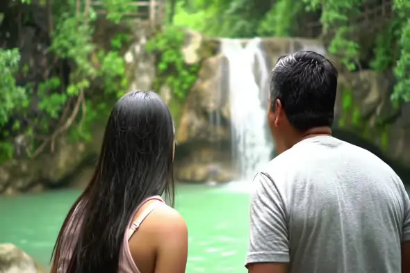 Couple Watching Waterfall in Scenic Forest Landscape