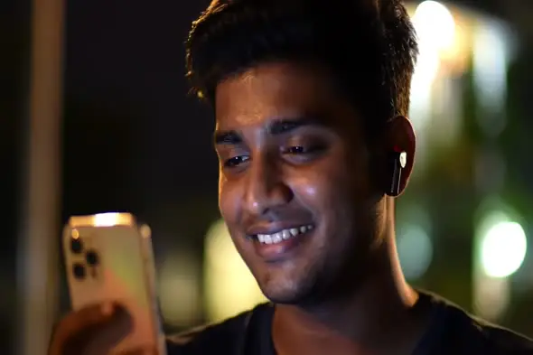Smiling Man Using Smartphone at Night