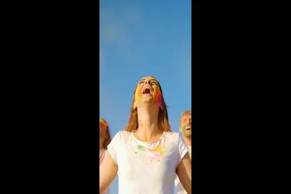 Joyful Celebration with Colorful Holi Powder Against Blue Sky