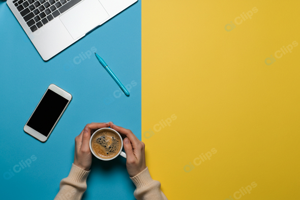 Laptop Workspace with Coffee, Smartphone, and Pen on Colorful Background