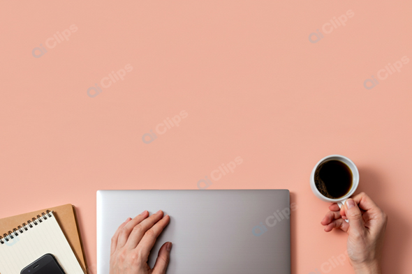 Laptop Workspace with Coffee and Notepad on Peach Background